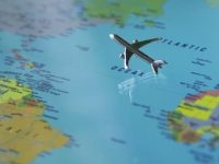 Formation continue dans le domaine du commerce international figurine d'avion argenté survolant un planisphère